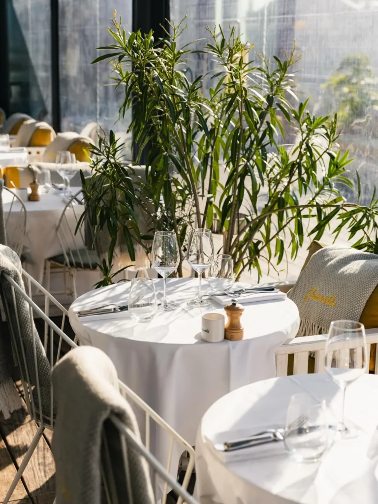 Outdoor dining table surrounded by greenery at Perruche Paris