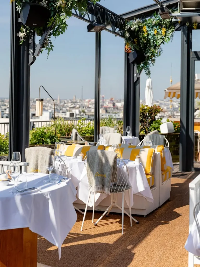 Elegant terrace dining area at Perruche Paris overlooking Paris