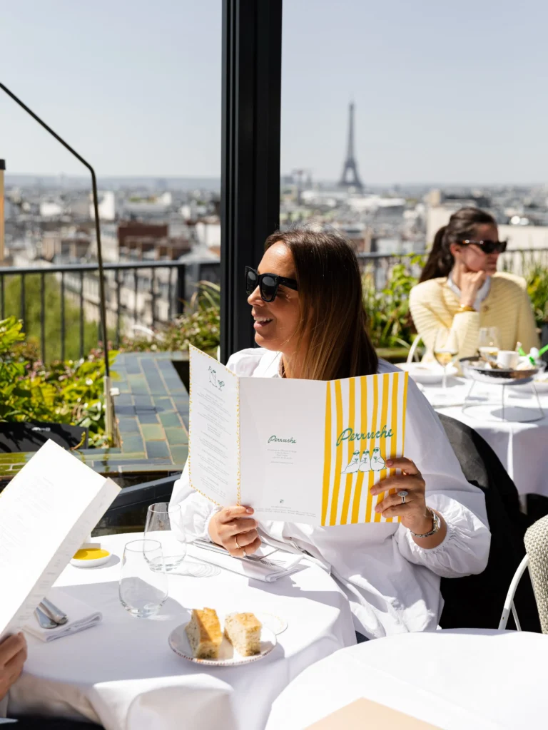 Outdoor terrace dining at Perruche Paris with the Eiffel Tower in the distance