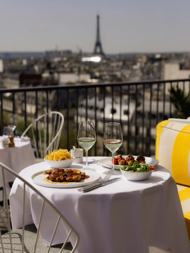 Outdoor table set for dining at Perruche Paris overlooking Paris