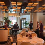 Warmly lit dining room with elegant tables at Plaza Athenee in Paris