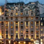 Illuminated facade of the Prince de Galles Paris hotel at dusk