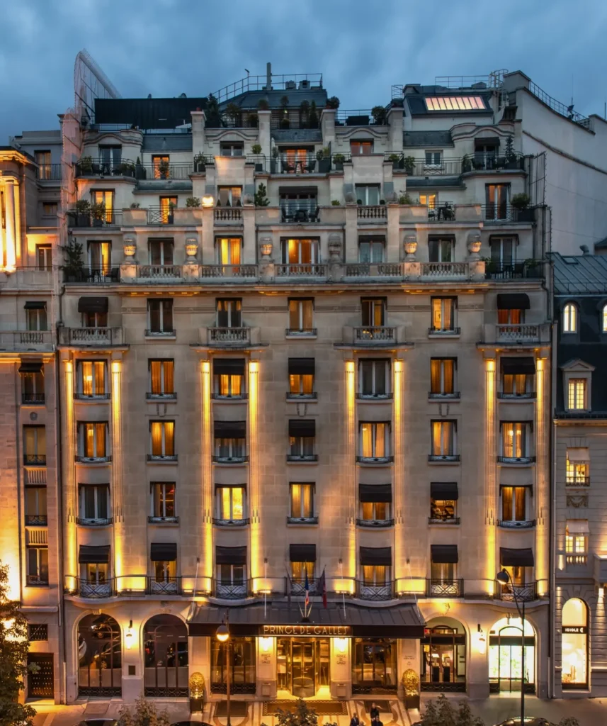 Illuminated facade of the Prince de Galles Paris hotel at dusk