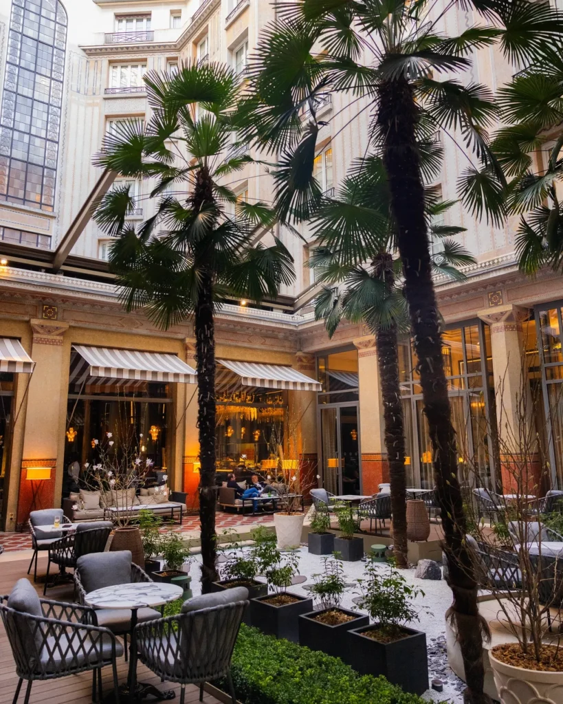 Lush courtyard with palm trees and outdoor seating at the Prince de Galles Paris