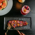 Colorful gourmet dish and cocktail at the Prince de Galles Paris