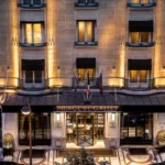 Illuminated entrance of the Prince de Galles Paris hotel at night