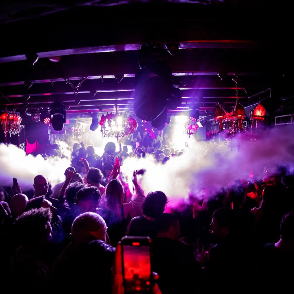 Guests dancing under nightclub lights at Raspoutine Paris