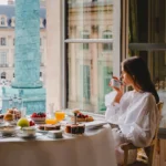 Guest enjoying breakfast beside a window at the Ritz Paris