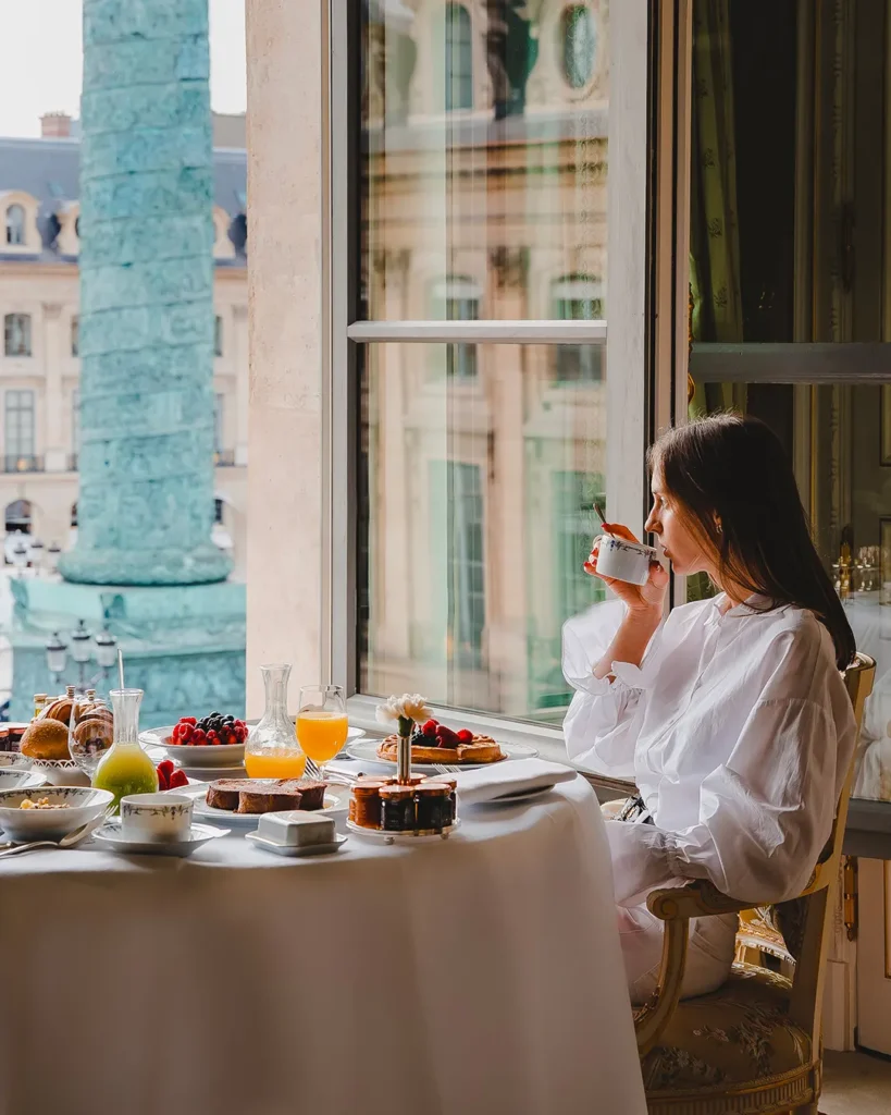 Guest enjoying breakfast beside a window at the Ritz Paris