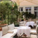Outdoor dining area surrounded by greenery at the Ritz Paris