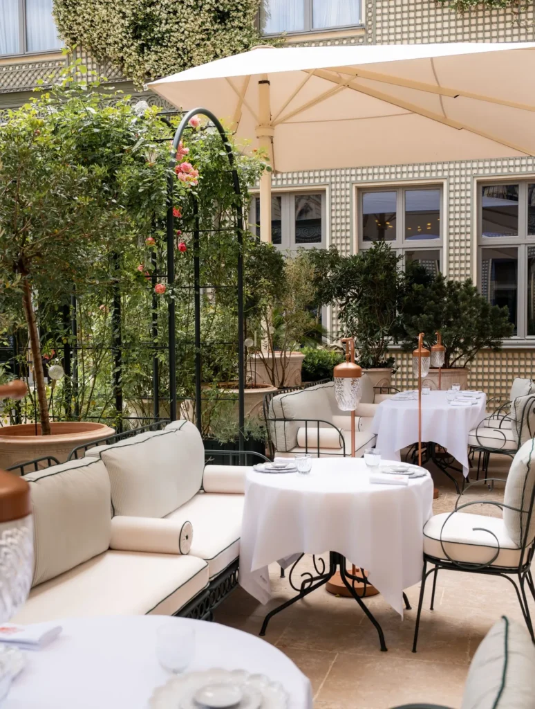 Outdoor dining area surrounded by greenery at the Ritz Paris