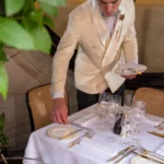 Server arranging a dish at a table inside Scott's Mayfair