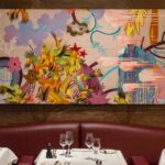 Elegant dining booth with colorful artwork at Scott's Mayfair in London