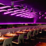 Purple-lit bar and dining area inside STK Milan