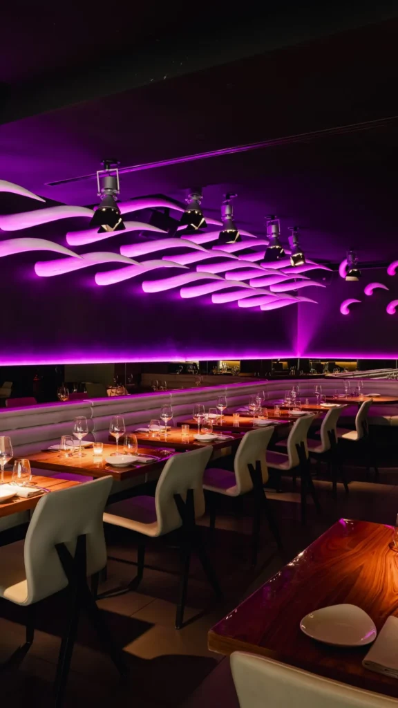 Purple-lit bar and dining area inside STK Milan