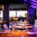 Elegant dining room with tables and purple lighting at STK Milan