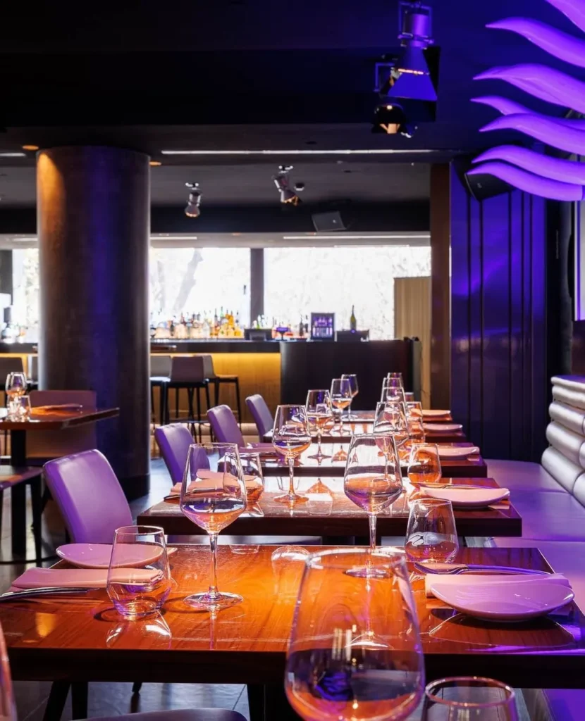 Elegant dining room with tables and purple lighting at STK Milan