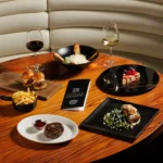 Dining table set with gourmet dishes inside STK Milan