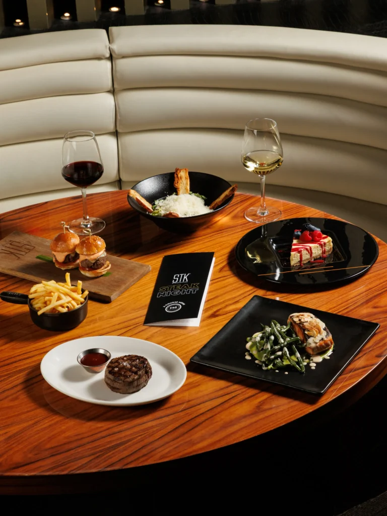 Dining table set with gourmet dishes inside STK Milan