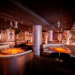 Private dining room with a bar and curved seating at STK Milan