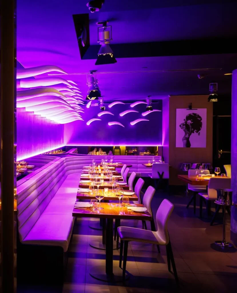 Purple-lit restaurant interior at STK Milan