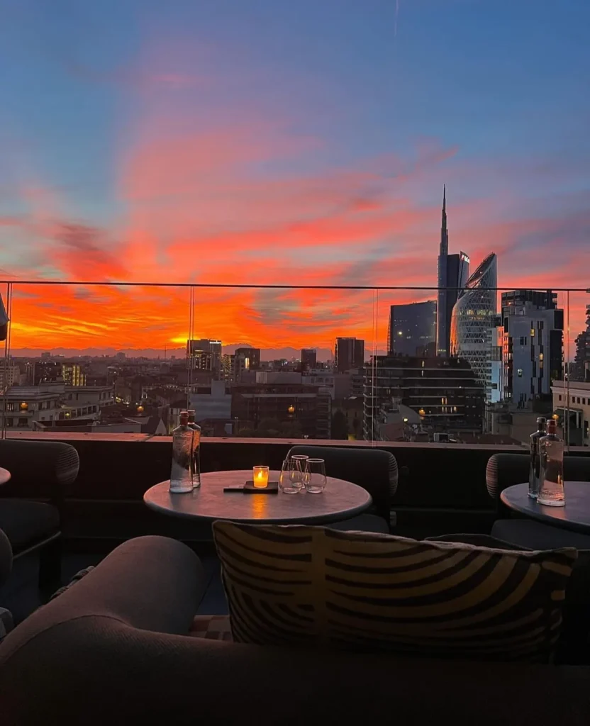 Rooftop dining area at STK Milan overlooking the Milan skyline at sunset