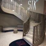 Curved staircase and STK Milan logo inside the restaurant