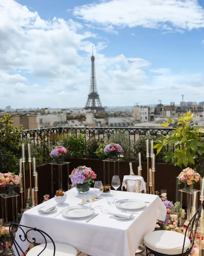 Rooftop dining table with flowers and Eiffel Tower views at The Peninsula Paris