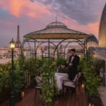 Rooftop dining terrace at sunset with the Eiffel Tower at The Peninsula Paris