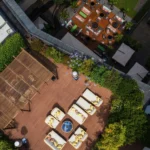 Overhead view of outdoor dining tables and landscaped terraces surrounded by greenery at Bulgari Hotel Milano
