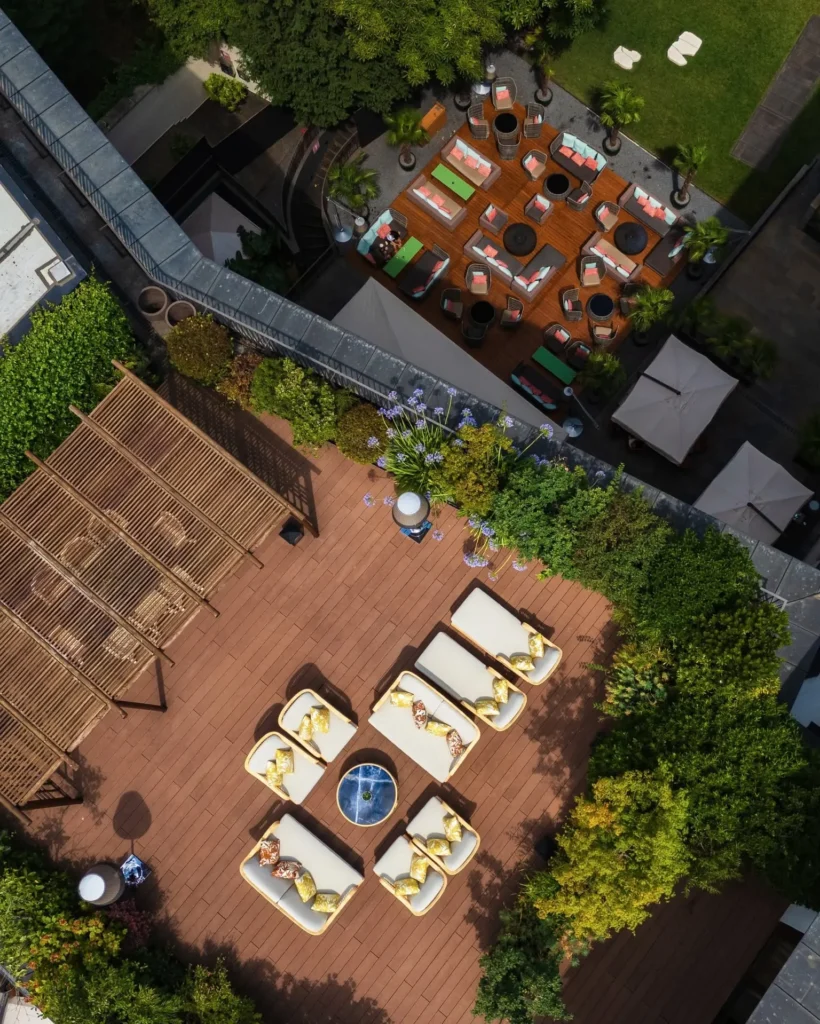 Overhead view of outdoor dining tables and landscaped terraces surrounded by greenery at Bulgari Hotel Milano
