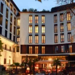 Bulgari Hotel Milano facade illuminated at dusk with warm lights and a welcoming entrance