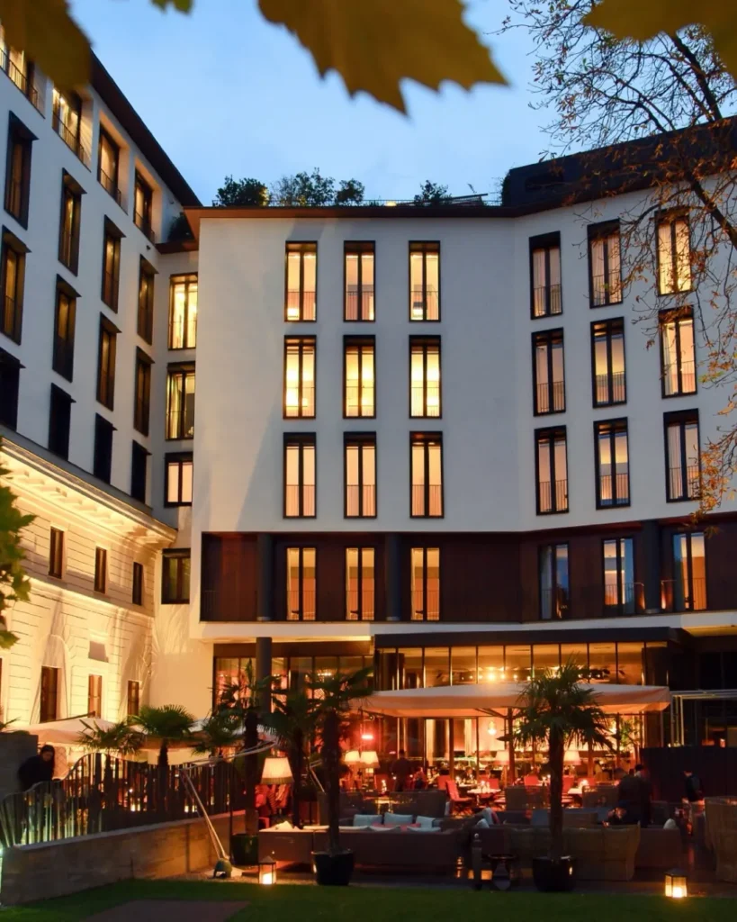 Bulgari Hotel Milano facade illuminated at dusk with warm lights and a welcoming entrance