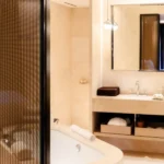 Elegant marble bathroom with a freestanding bathtub, glass shower and refined finishes at Bulgari Hotel Milano