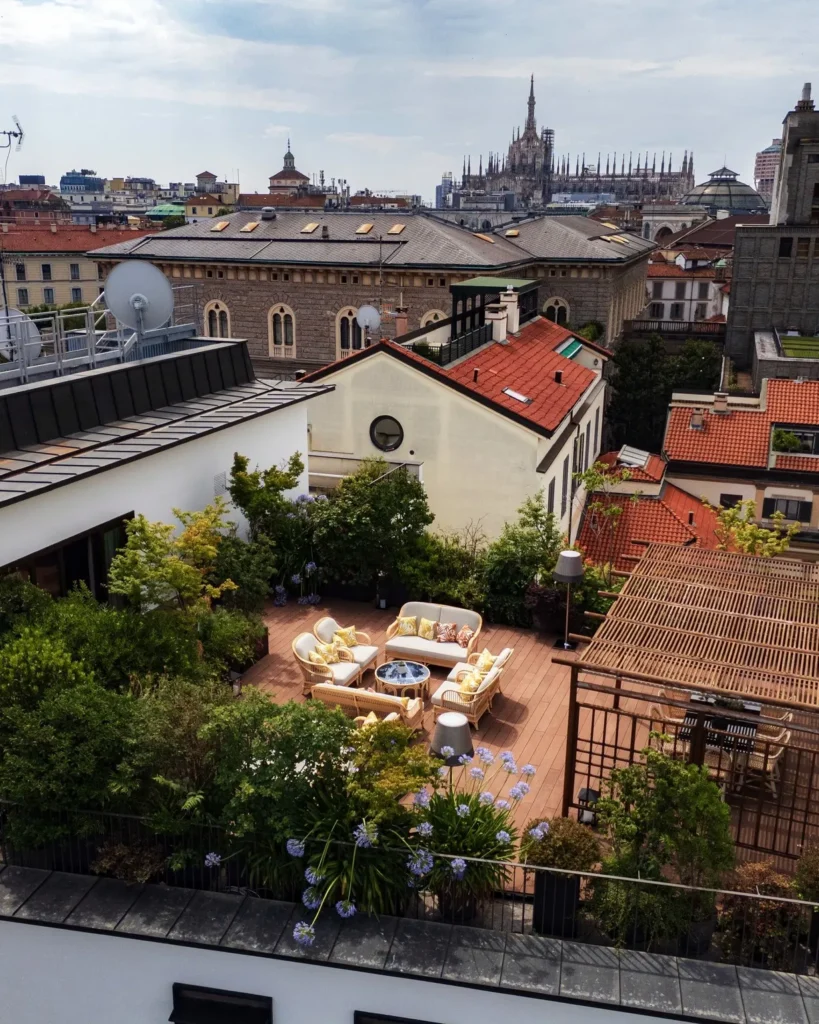 Rooftop view across Milan with historic buildings and a landscaped hotel terrace at Bulgari Hotel Milano