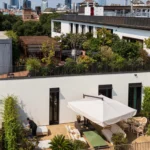 Private rooftop terrace with outdoor seating, greenery and views across Milan at Bulgari Hotel Milano