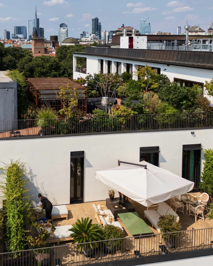 Private rooftop terrace with outdoor seating, greenery and views across Milan at Bulgari Hotel Milano