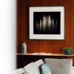 Refined hotel suite interior with a wood-paneled wall, framed artwork and elegant upholstered seating at Bulgari Hotel Milano
