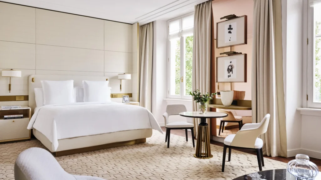 Bright luxury hotel bedroom with a king-size bed, neutral furnishings and elegant decorative details at Four Seasons Hotel Milano