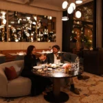Elegant candlelit restaurant interior with comfortable seating, warm lighting and beautifully set dining tables at Four Seasons Hotel Milano