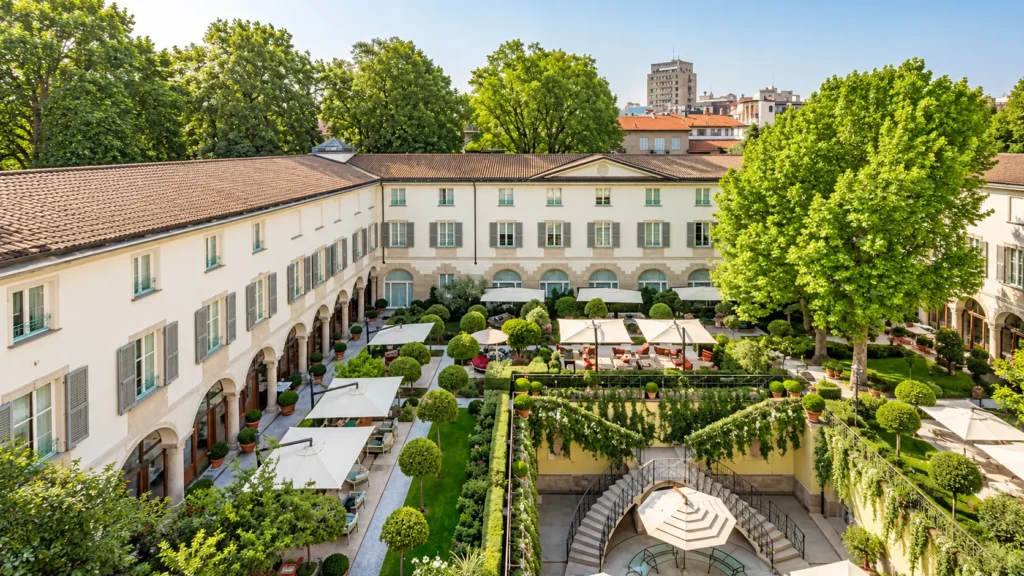 Elevated view of the green courtyard garden with outdoor seating and historic buildings at Four Seasons Hotel Milano