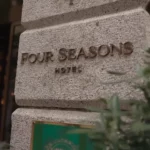 Close-up of the Four Seasons Milano name engraved on a stone plaque outside the hotel