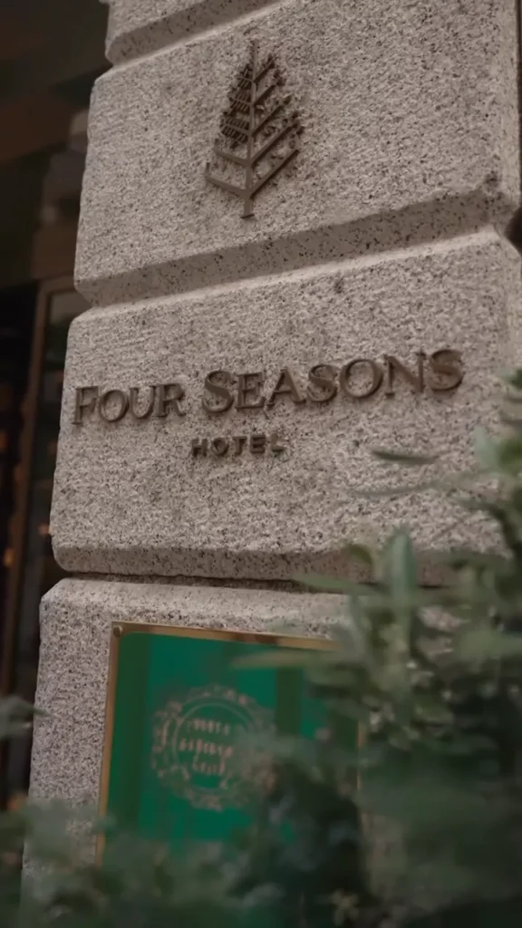 Close-up of the Four Seasons Milano name engraved on a stone plaque outside the hotel