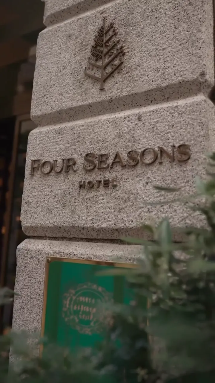 Close-up of the Four Seasons Milano name engraved on a stone plaque outside the hotel