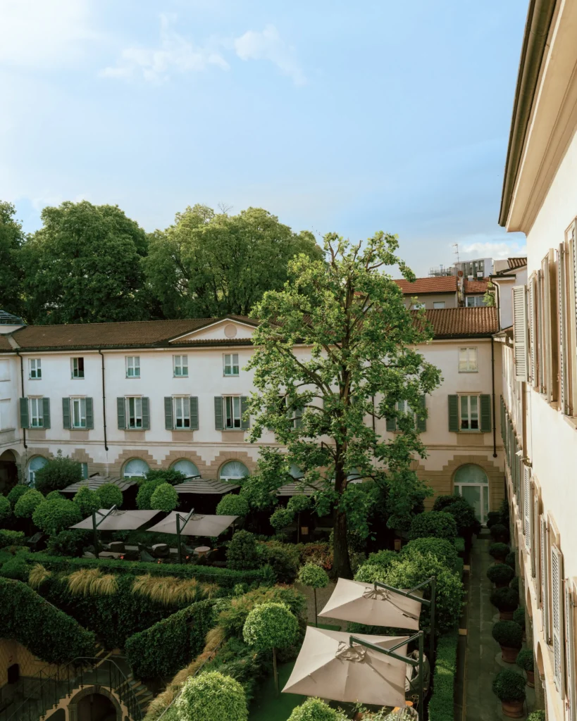 Beautiful landscaped garden courtyard with manicured hedges and outdoor seating at Four Seasons Hotel Milano