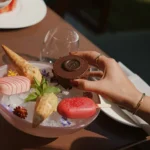 Chef presenting a gourmet dessert with colorful ingredients and elegant plating at Four Seasons Hotel Milano