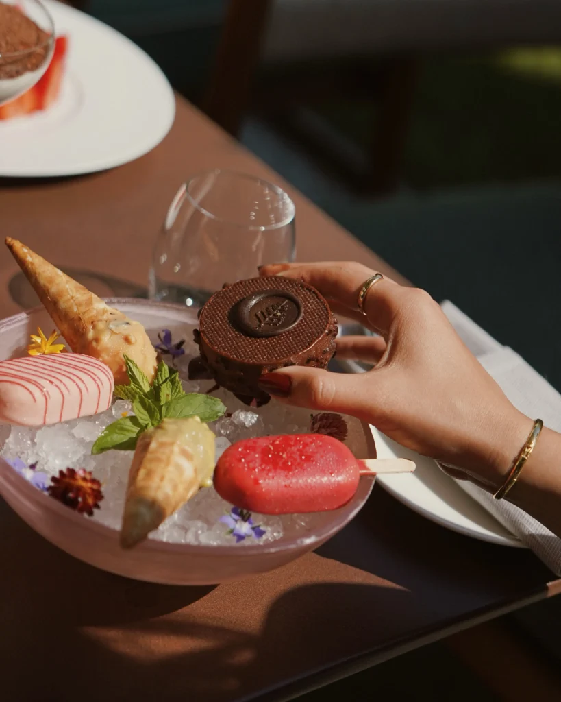 Chef presenting a gourmet dessert with colorful ingredients and elegant plating at Four Seasons Hotel Milano