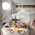 Breakfast tray with fresh fruit, pastries and drinks arranged beside the bed in a luxury room at Four Seasons Hotel Milano