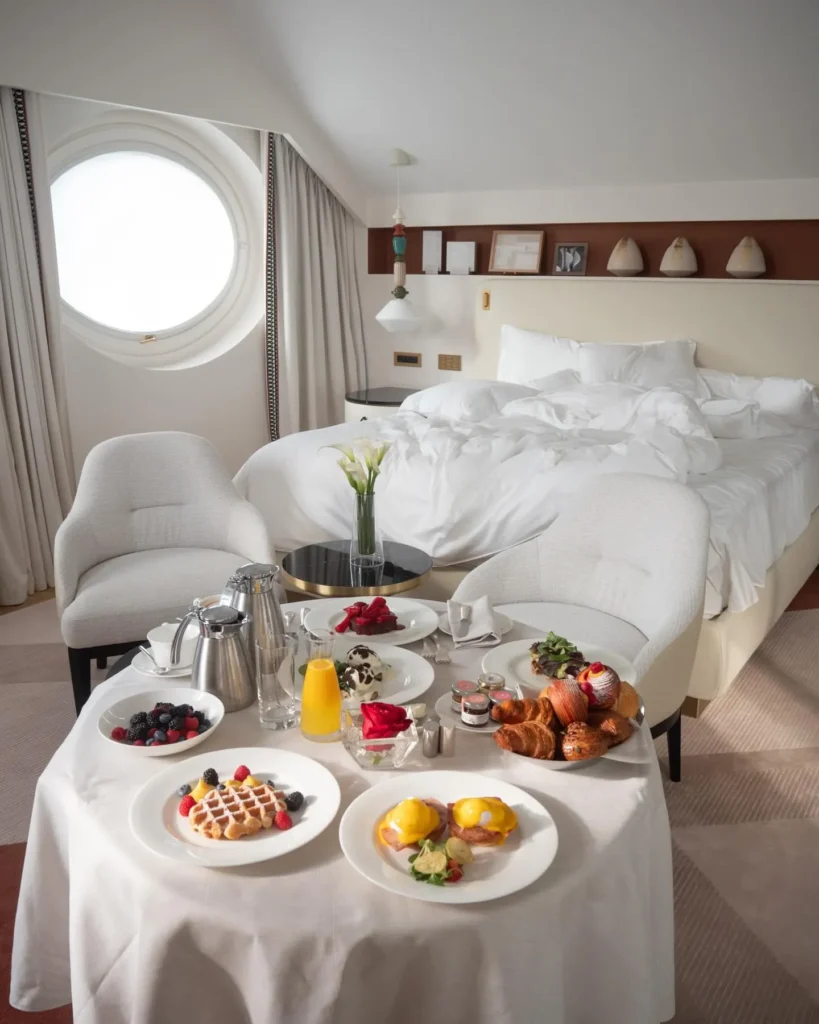 Breakfast tray with fresh fruit, pastries and drinks arranged beside the bed in a luxury room at Four Seasons Hotel Milano
