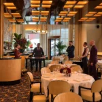 Elegant restaurant interior with warm lighting, art deco details and refined dining tables at Hôtel Plaza Athénée Paris